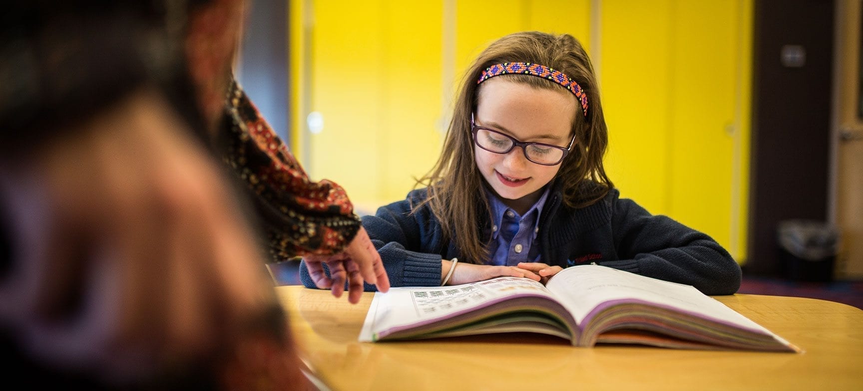 A girl is reading a book at the table