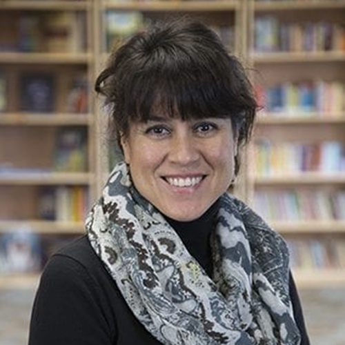 A woman with bangs and a scarf around her neck.